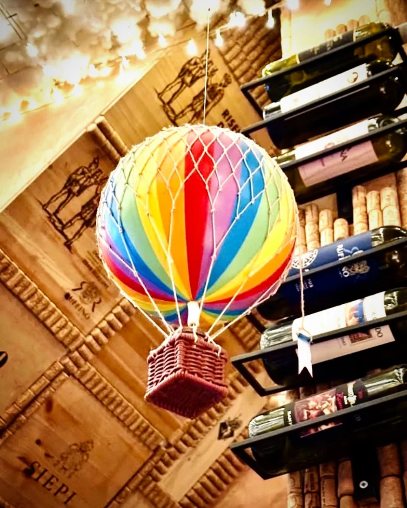 Mongolfiera decorativa a spicchi arcobaleno sospesa accanto alla cantina a vista