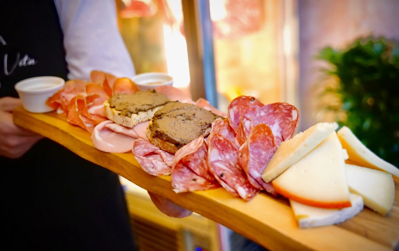 Tagliere di salumi toscani, crostini di fegatini e pecorini serviti su tavola di legno