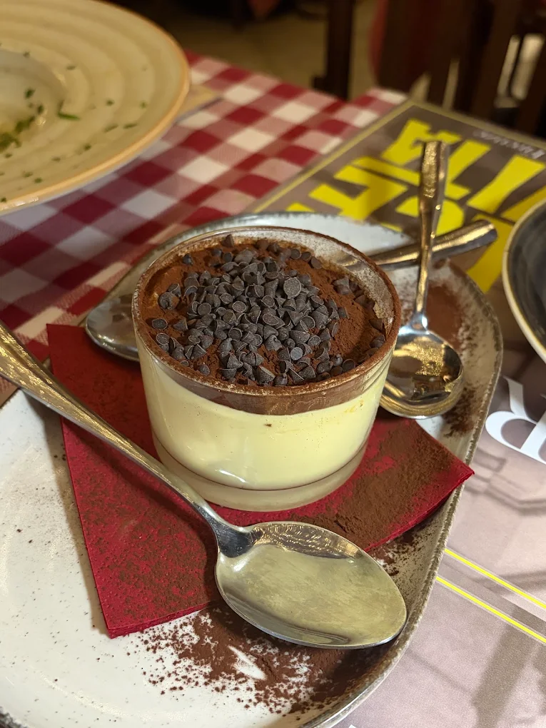 Tiramisù della casa in coppa di vetro con gocce di cioccolato