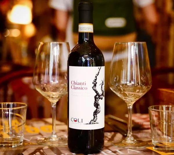 Bottiglia di Chianti Classico e calici sul tavolo dell'osteria